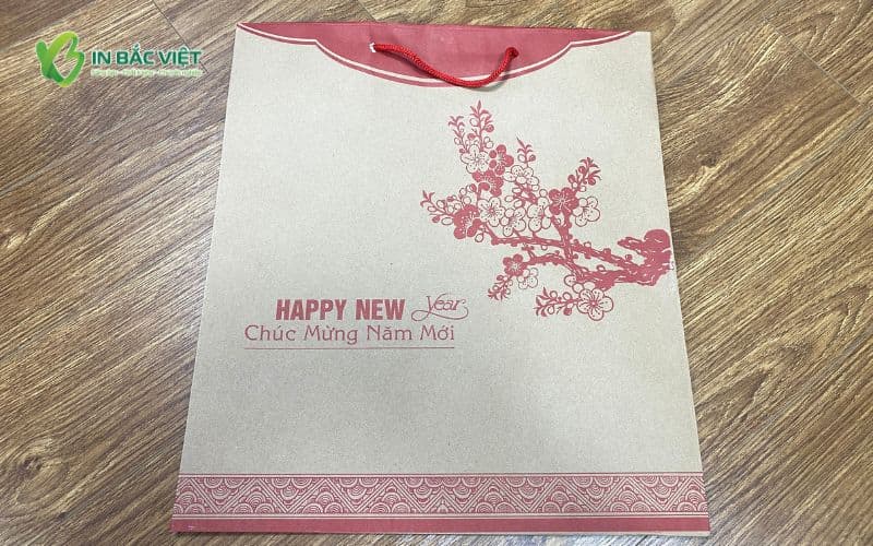 Túi giấy kiểu dáng dẹt chất liệu kraft dùng để đựng lịch Tết, in họa tiết đỏ truyền thống.