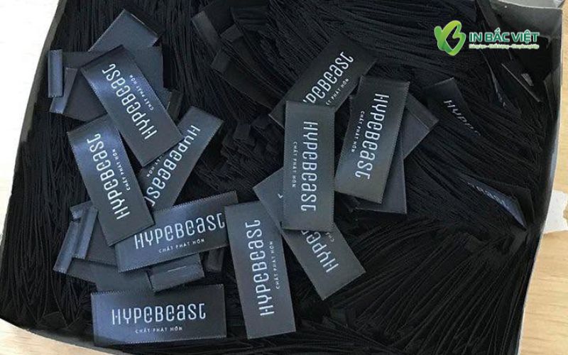 Mẫu mác lụa Satin đen đẹp, in logo thương hiệu sắc nét tại In Bắc Việt